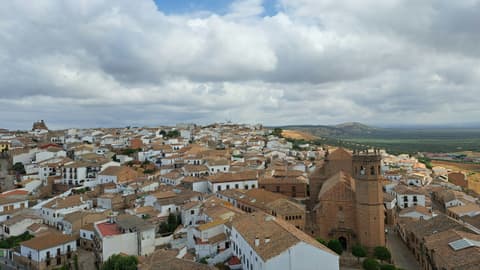 Vista aérea de Baños de la Encina, en la provincia de Jaén, con su iglesia, casas blancas y olivares al fondo